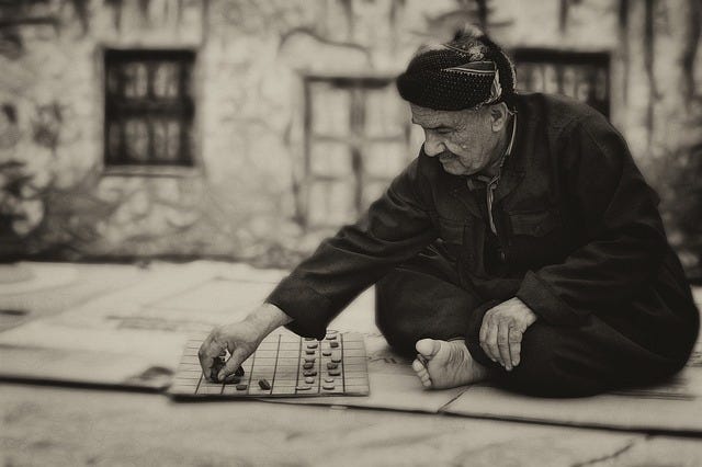 man playing checkers on street