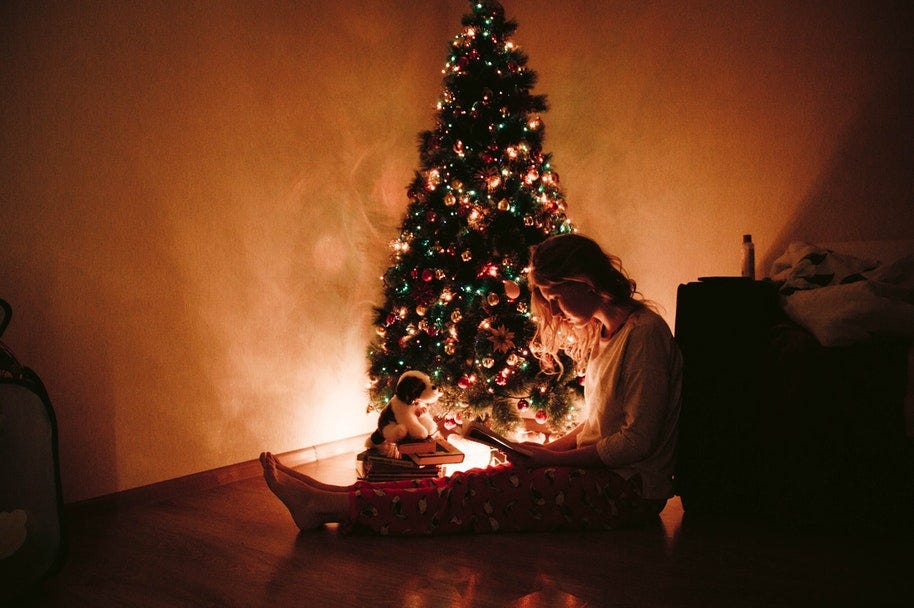 woman sitting beside Christmas tree