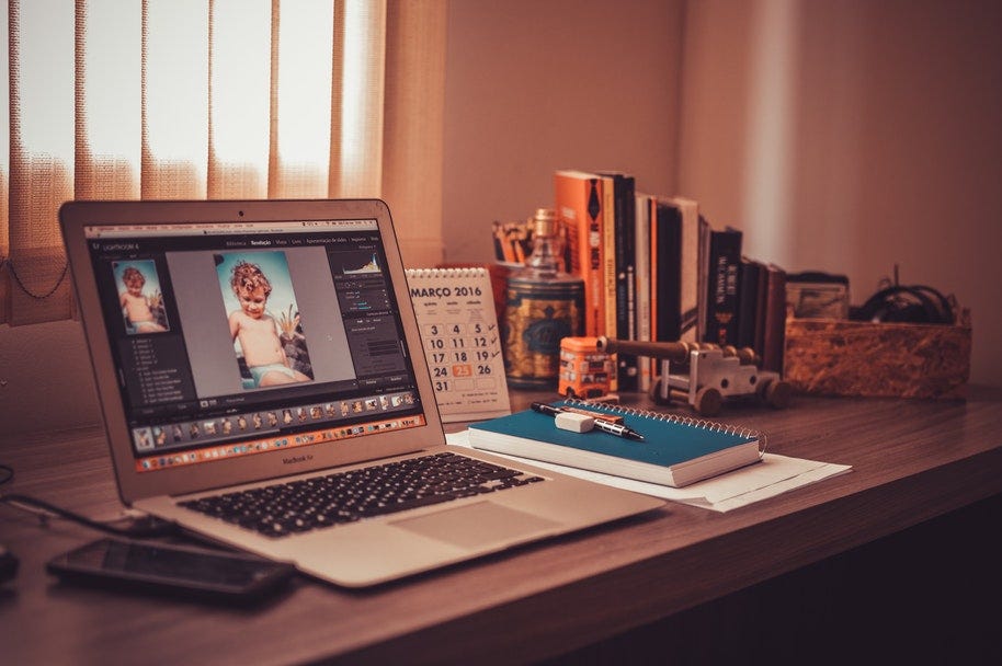 a laptop on a desk open to Lightroom software