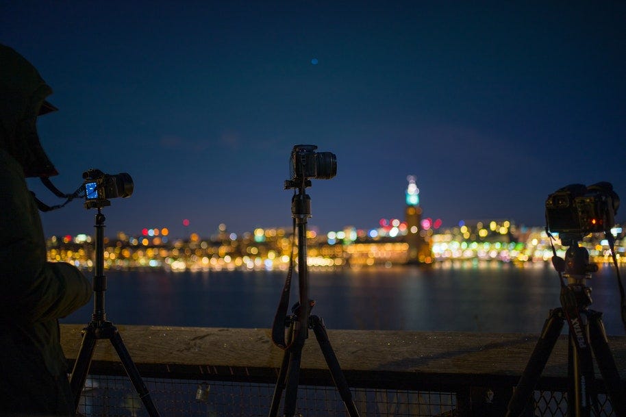 cameras on tripods shooting city night scene