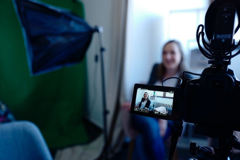 video shoot with camera pointed at woman in chair