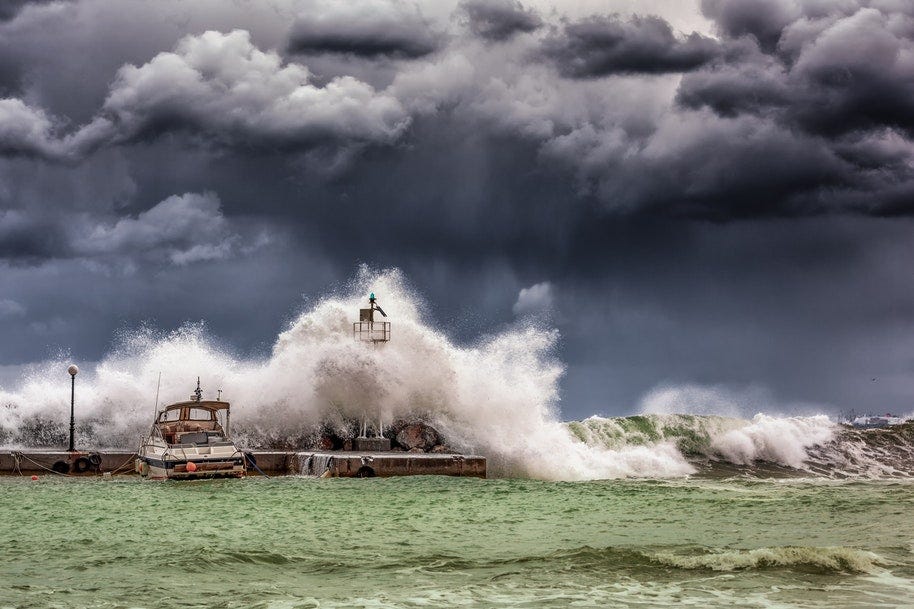 waves crashing into lighthouse in storm