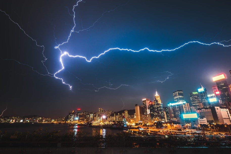 Lightning over city skyline and water.