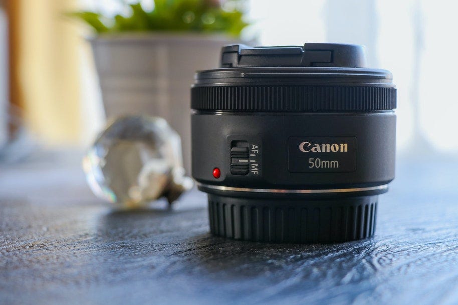 One of the best Canon lenses for portraits - the 50mm lens alone on a tabletop.