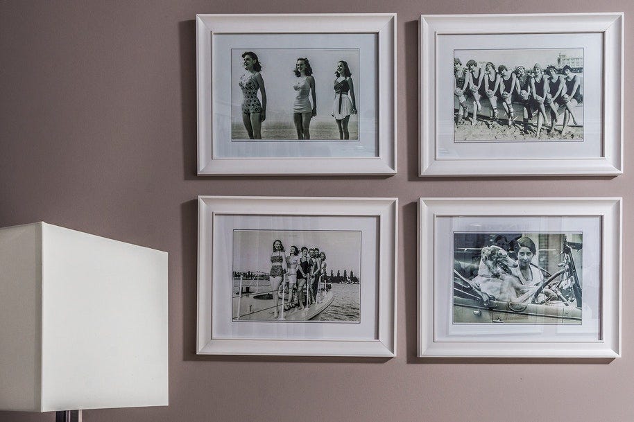 A photo wall gallery of four black and white photos in white frames.